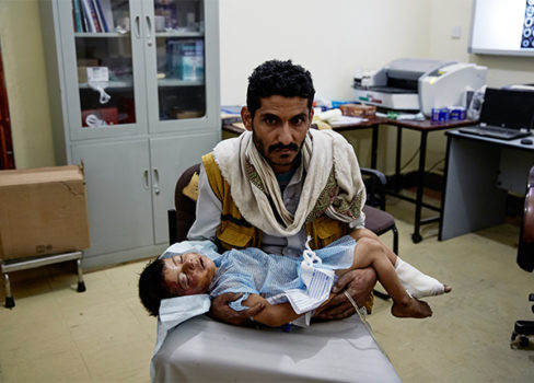En far holder sit sårede barn på hospitalet vi støtter i Sa'ada. © Sebastiano Tomada/Getty Reportage