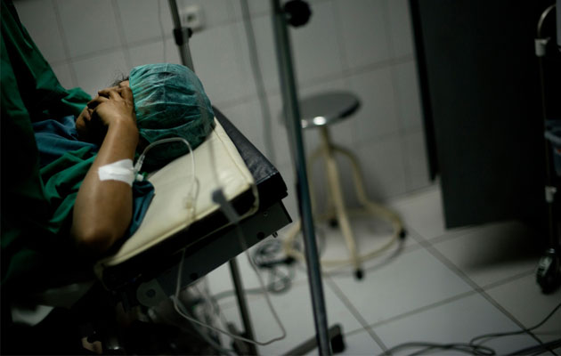 En kvinde får hjælp til fødslen på et hospital under krigen i Afghanistan.