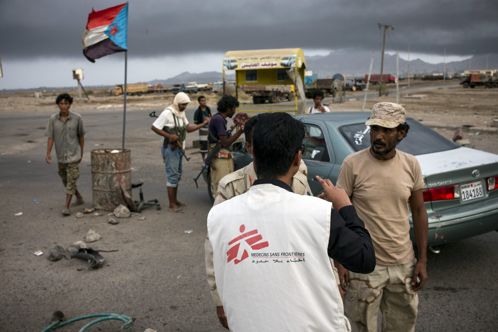En medarbejder fra Læger uden Grænser taler med væbnede mænd på et checkpunkt i Aden, Yemen.