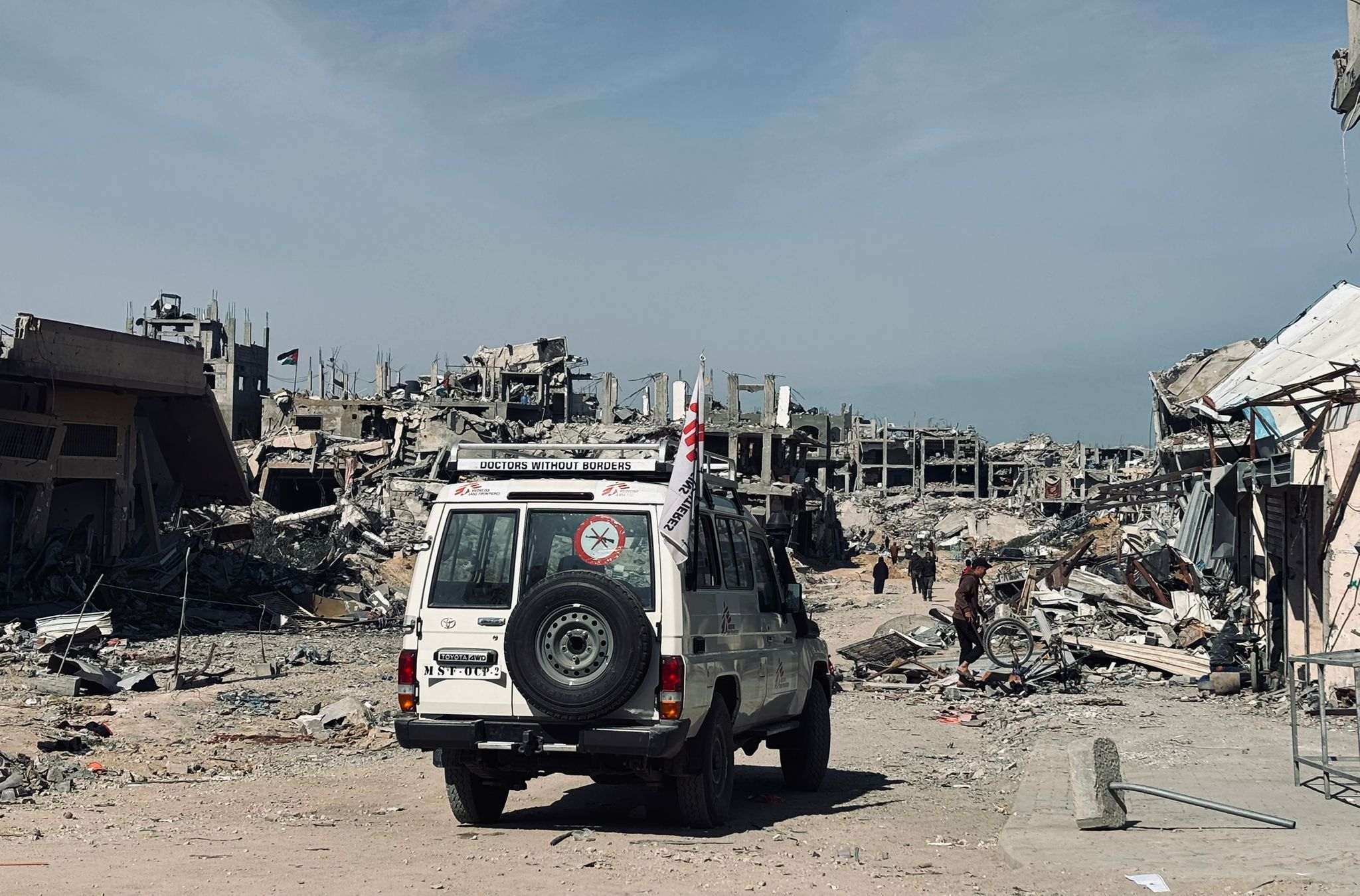 An MSF vehicle passes in front of ruined buildings in Jabalia - Palestinian Territories