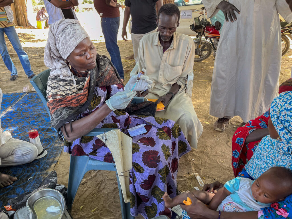 In the village of Allerye, a vaccination officer administers a dose of vaccine to a mother and her son - Chad