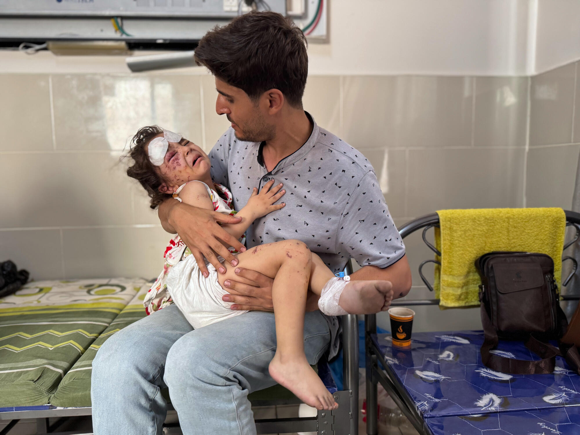 26. juni 2025. Ahmed trøster sin fire-årige datter Julia, efter hun er blevet såret i et luftangreb i Gaza By.