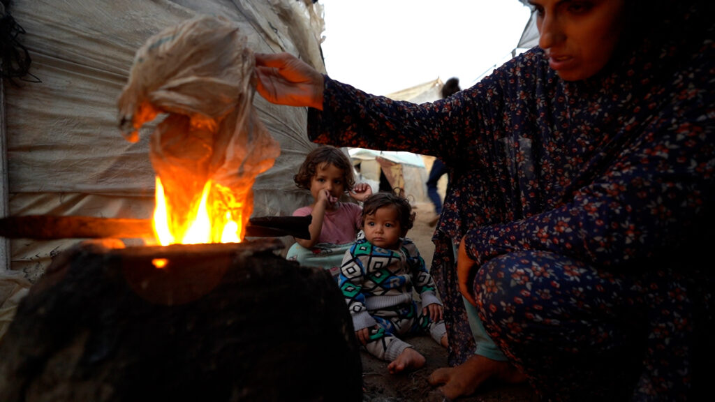 Uden adgang til gas forsøger Yasmin at tænde et bål med plastik for at lave et måltid til sine børn under de desperate forhold i Gaza.