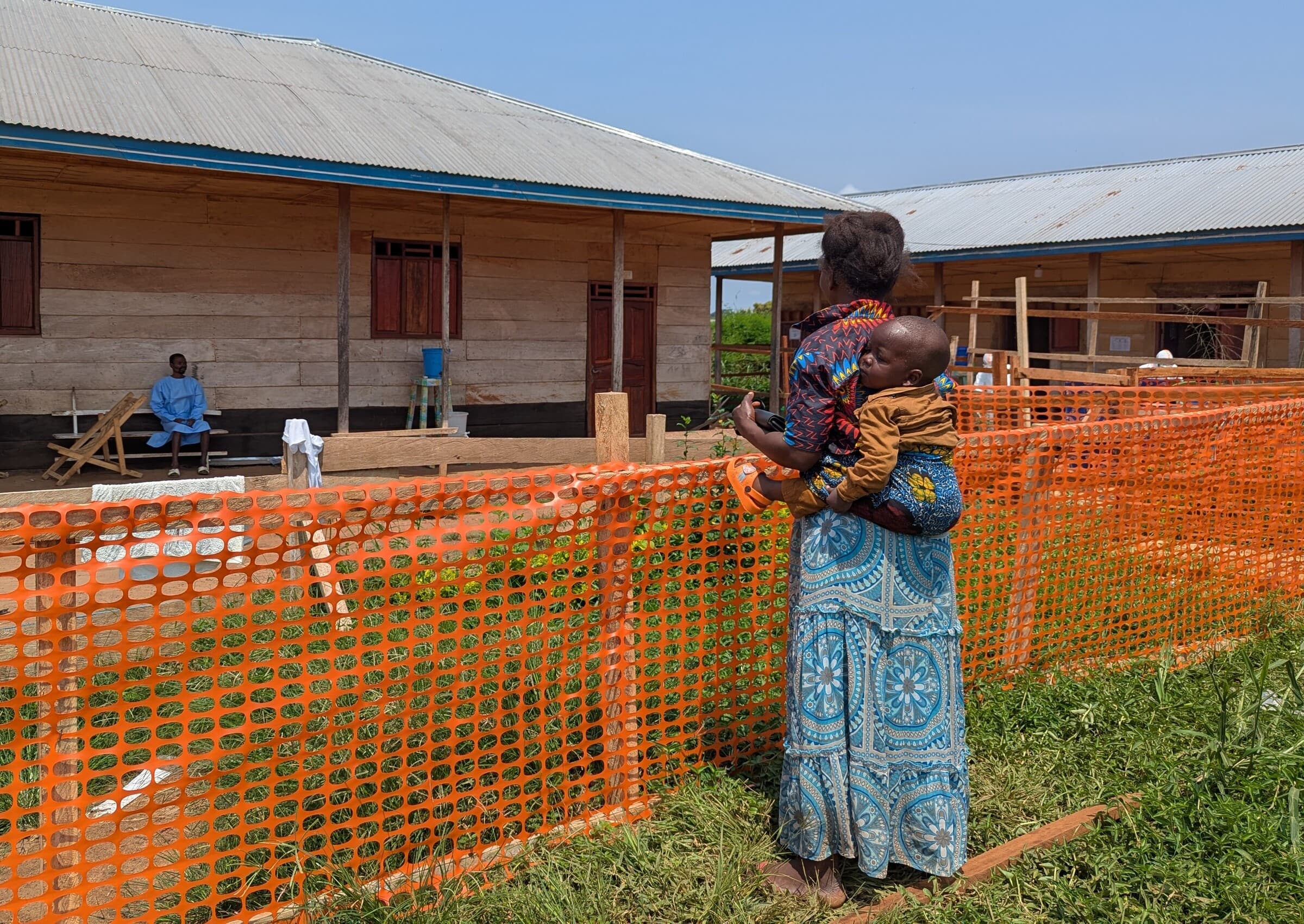 En patient med ebola taler med sin kone og søn under deres besøg på ebolabehandlingscentret i Nia-Nia. Familiemedlemmerne skal opholde sig uden for området med smittede patienter, så sygdommen ikke spreder sig yderligere.