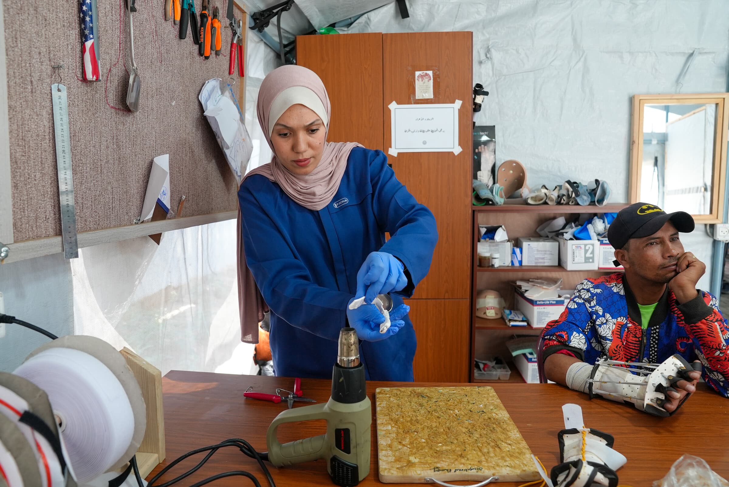 2. juni 2026.Fysioterapeuten Doaa opvarmer et stykke termoplastisk materiale for at forme det til en specialtilpasset skinne på vores felthospital, Al-Zawayda, i Gaza. Trods den såkaldte våbenhvile udsættes palæstinensere dagligt for vold. Det vurderes, at konflikten har efterladt 43.000 mennesker med livsforandrende skader, mens mere end 50.000 har behov for langvarig rehabilitering. Sundhedsministeriet i Gaza har dokumenteret omkring 6.000 amputationer, heraf på 1.500 børn.